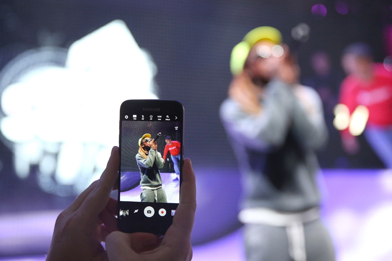 LOS ANGELES, CA - JUNE 14: A E3 Expo attendee takes a photo on a Samsung Galaxy S7 as rapper Lil Wayne performs onstage at the Samsung booth at E3 Expo 2016 on June 15, 2016 in Los Angeles, California. (Photo by Joe Scarnici/Getty Images for Samsung)