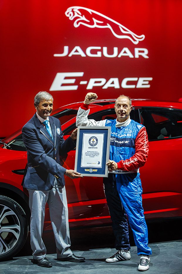 Jaguar stunt driver Terry Grant receives the Guinness World Record for longest barrel roll from adjudicator Pravin Patel at the global launch of the new Jaguar E-PACE at ExCel London.