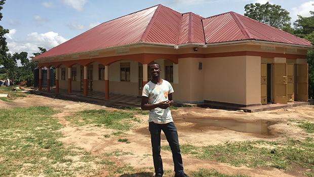 Denis Muwanguzi in front of the new Antenatal Care Building